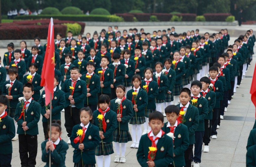 少先队员在烈士纪念碑前默哀。人民网记者 张隽摄