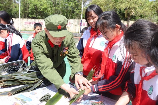 老兵与学生在红星学园一起包青团。受访单位供图