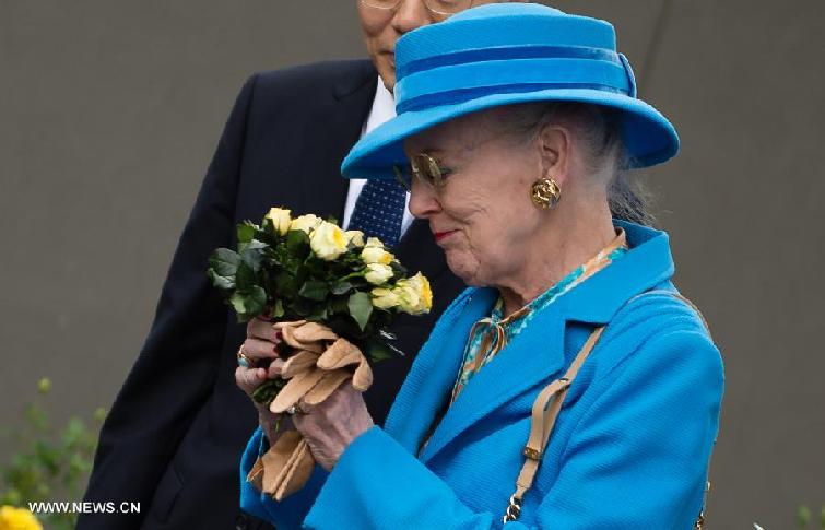 Queen of Denmark Margrethe II holds a bunch of 'Sindberg yellow roses', while visiting the Memorial Hall of the Victims in Nanjing Massacre by Japanese Invaders, in Nanjing, capital of east China's Jiangsu Province, April 27, 2014. 