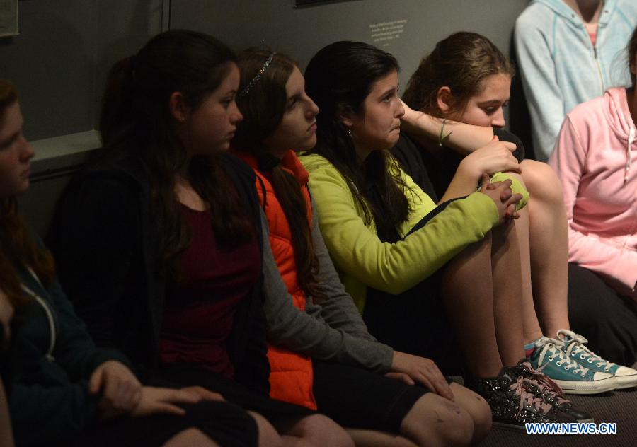 Students listen to a Holocaust survivor in the Museum of Jewish Heritage in New York City, the United States, on April 28, 2014. An event named 'A Living Memorial to the Holocaust' is held here for commemoration of Holocaust Remembrance Day on Monday. Holocaust survivors from Poland, Germany, and Belgium who are now living in New York met with more than 300 students and visitorsg here and shared with them what they had been thourgh during the Holocaust. (Xinhua/Wang Lei) 